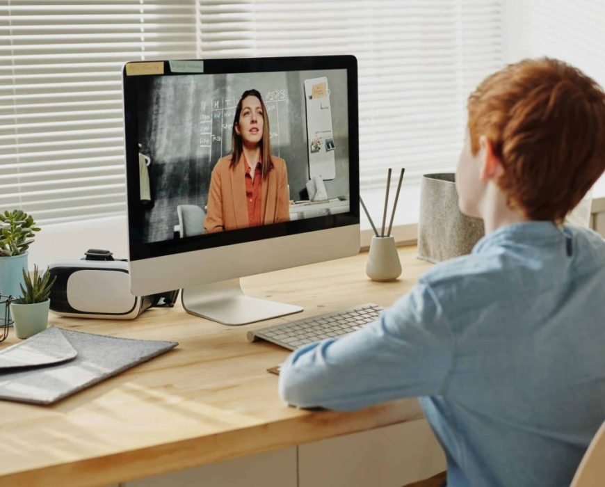 Jeune garçon prenant des cours en ligne sur mac Jeune garçon prenant des cours en ligne sur mac